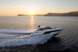 Zijaanzicht van een Fairline Targa 58 GTO die over het water vaart bij zonsondergang.