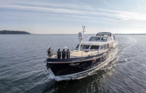 Luxury Grand Sturdy Linssen yacht named "Taurin" cruising on calm open water under a clear sky.
